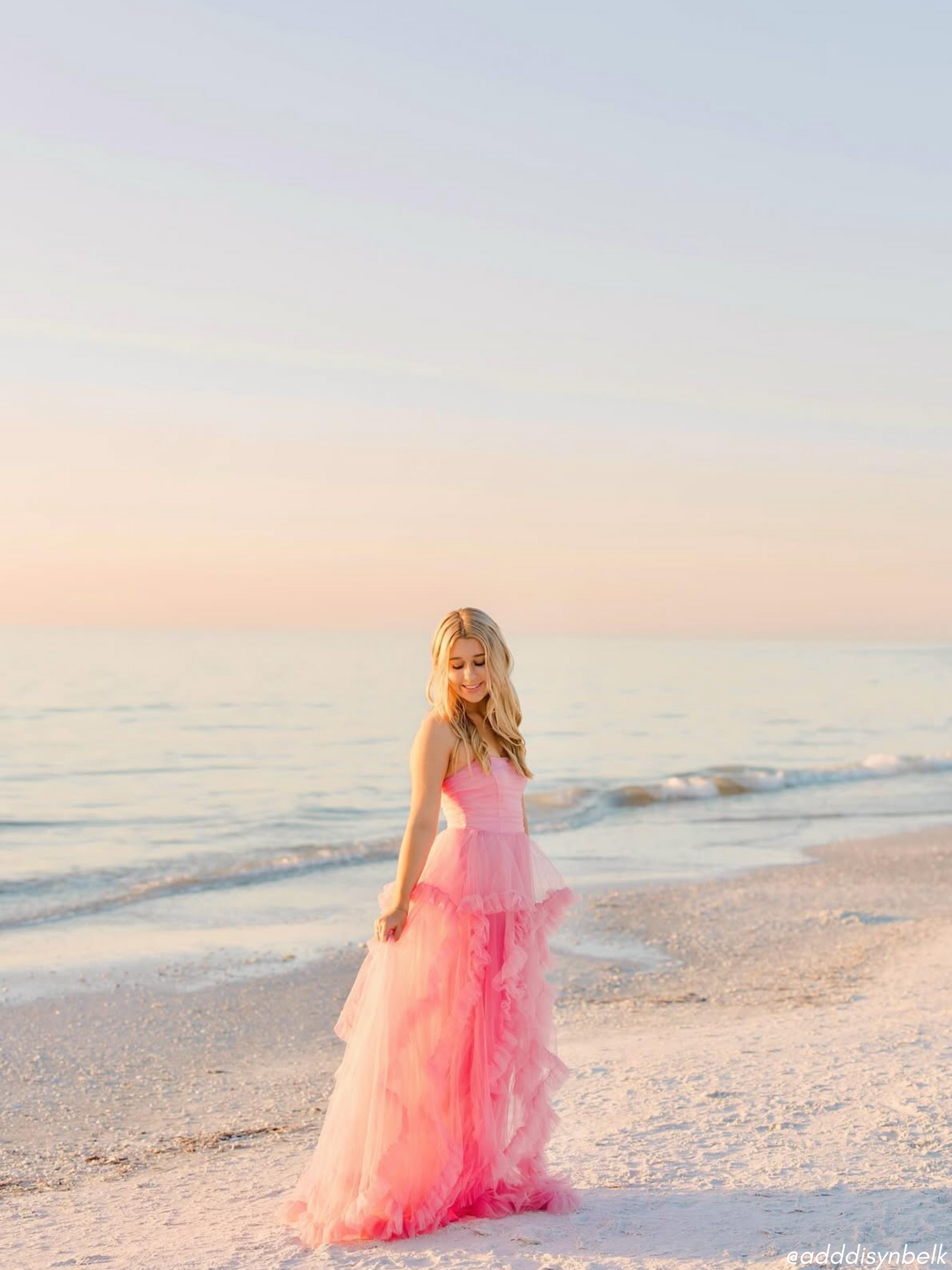 Pink tulle dress on a beach at sunset.