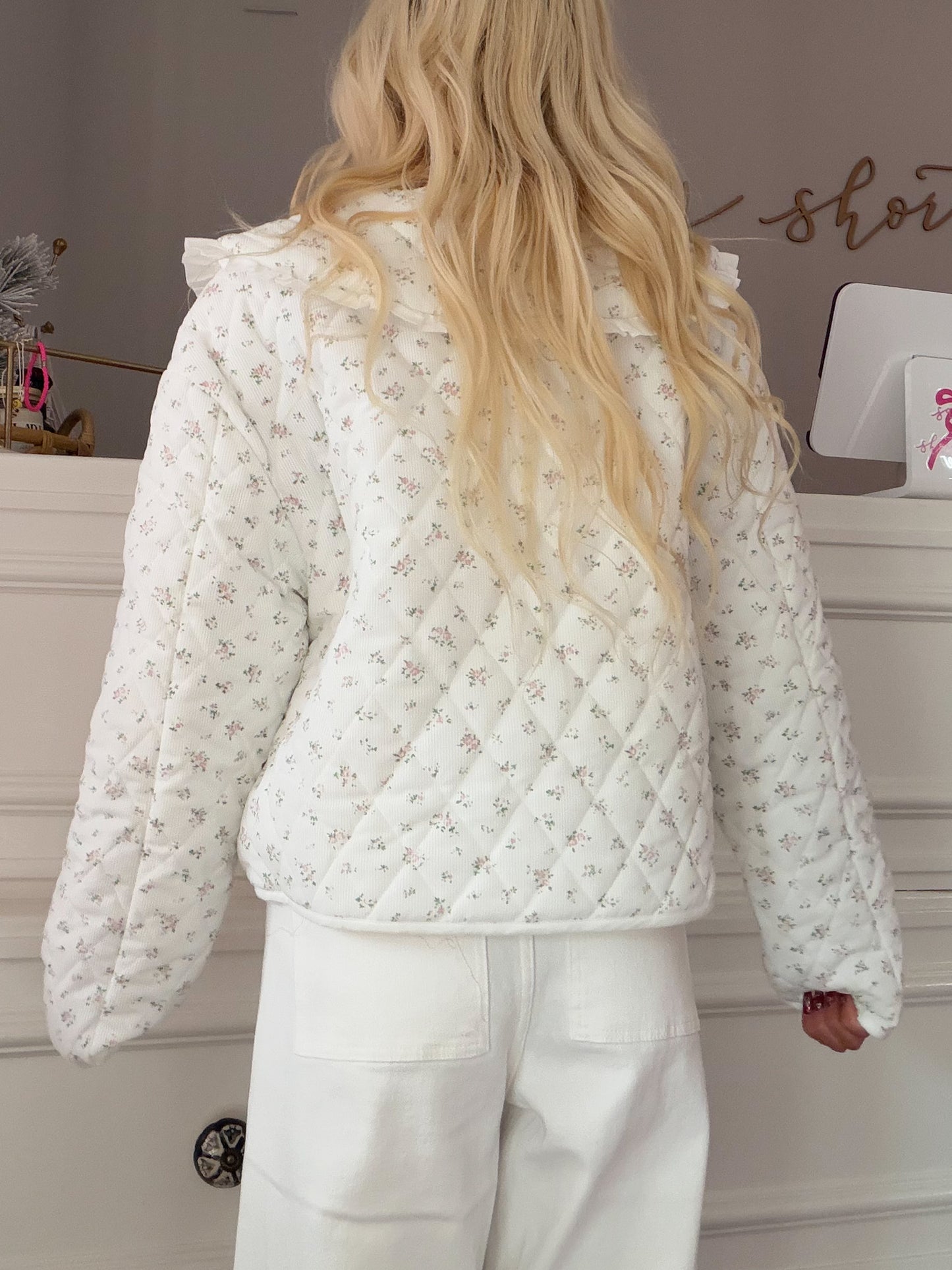 Cate Floral Jacket from Sassy Shortcake - Person wearing a white quilted jacket with floral pattern in a neutral setting