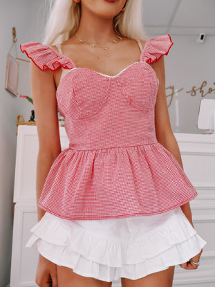 Red and white gingham top styled with white skirt for a sunny day look.
