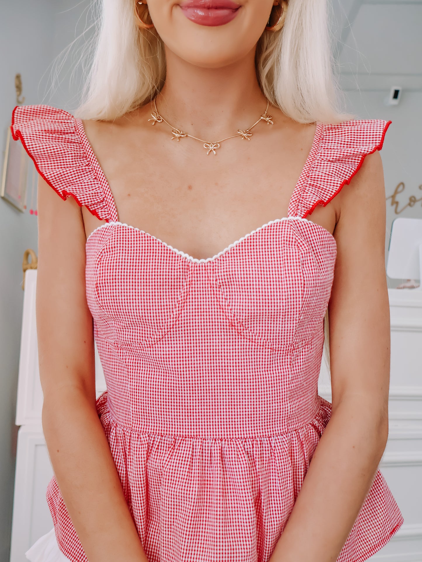 Close-up of red gingham pattern and smocked fabric on Cherry Soda Top.
