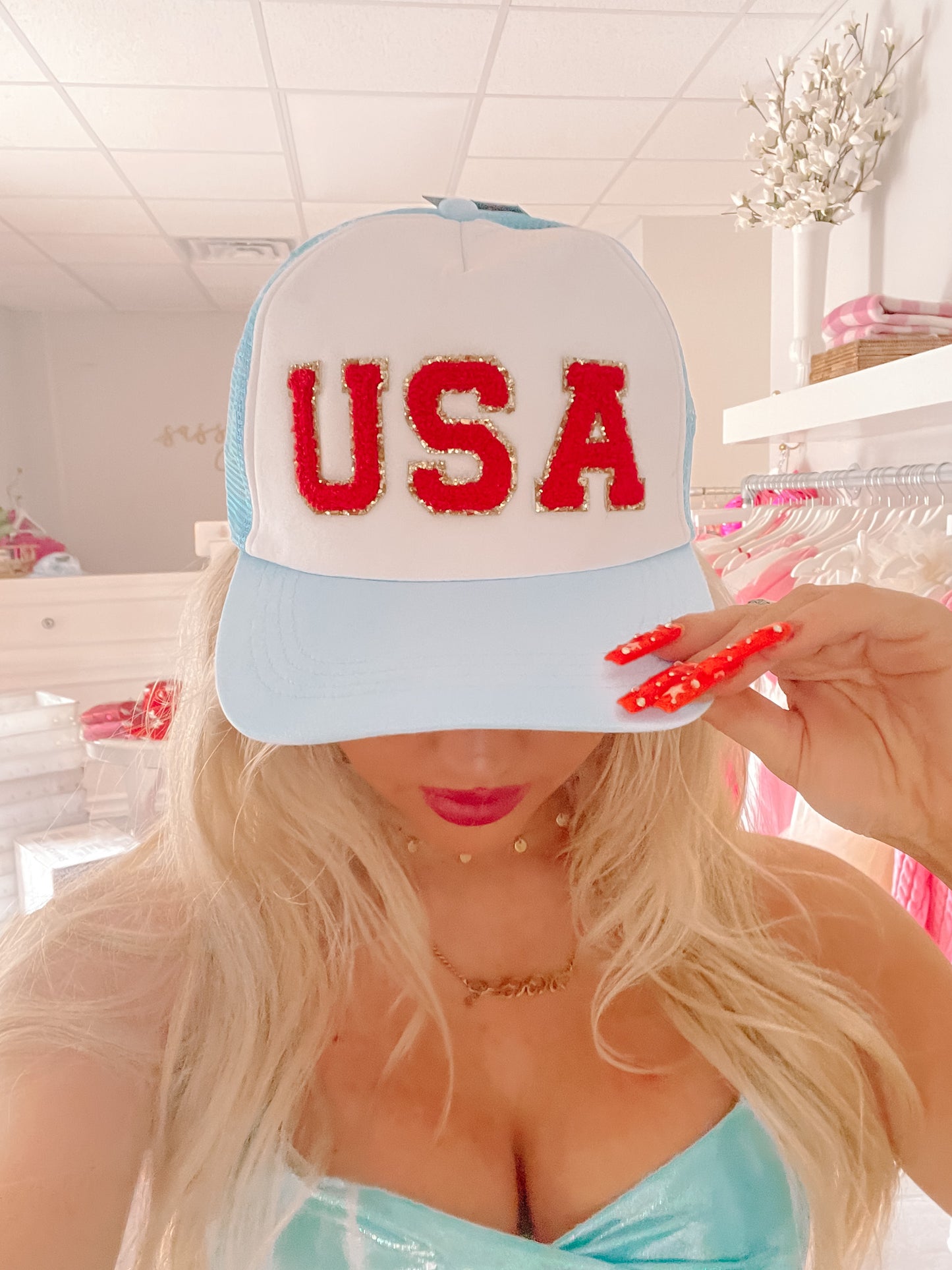 Light blue and white trucker hat with red "USA" lettering; gold accents.