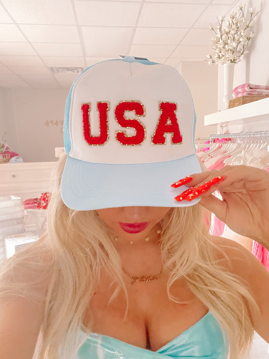 Light blue and white trucker hat with red "USA" lettering; gold accents from Sassy Shortcake