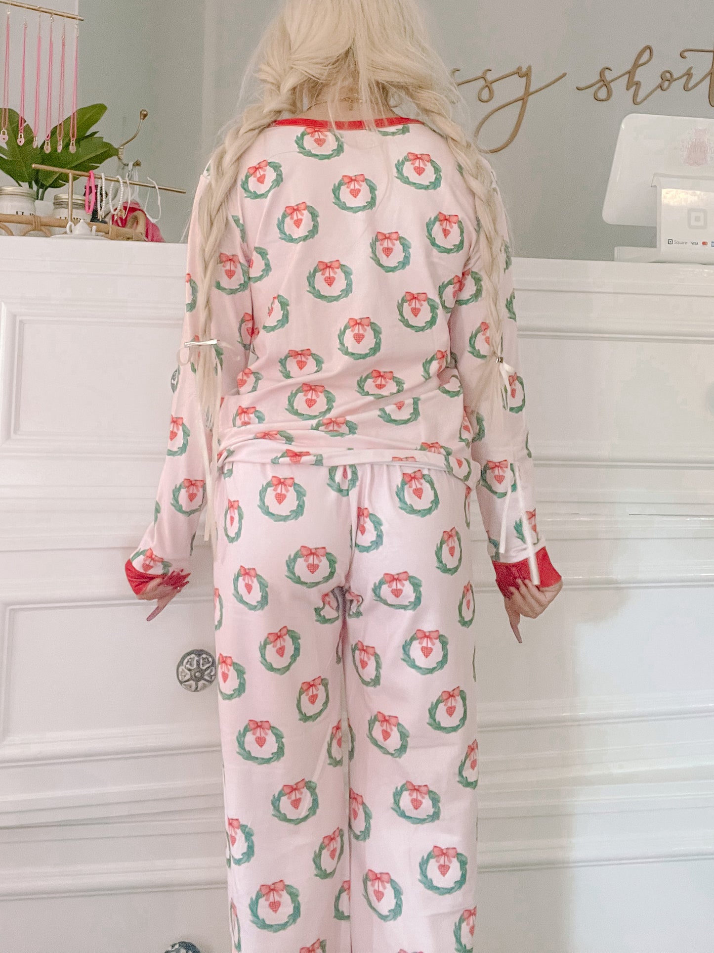 Pink pajama set featuring a festive wreath pattern; long sleeves and pants.