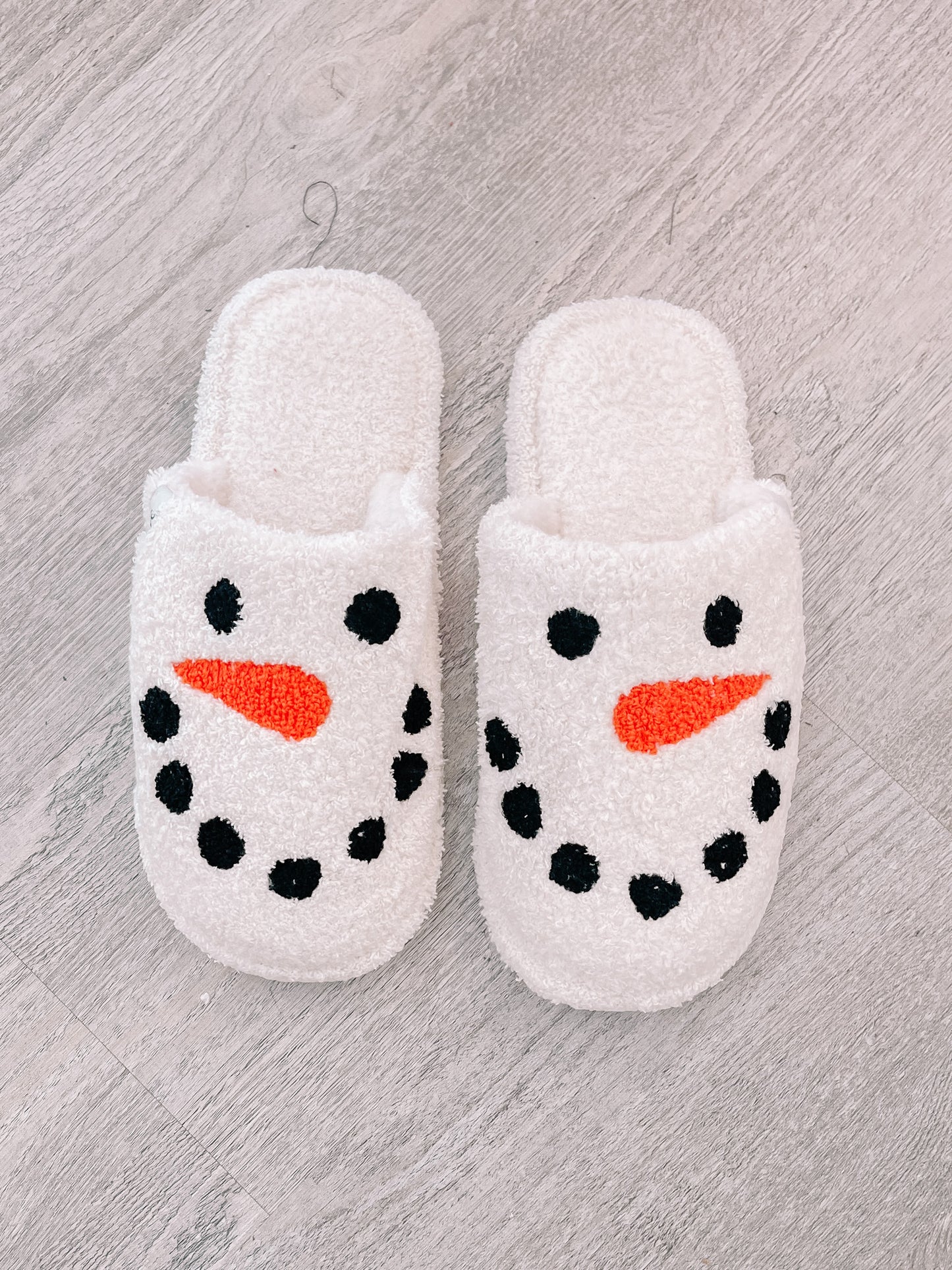 Cozy snowman slippers, white fuzzy fabric with embroidered face.