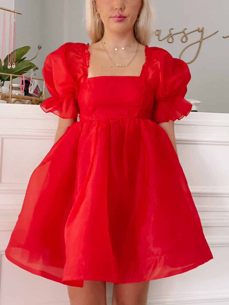 Red organza mini dress with puff sleeves and square neckline.