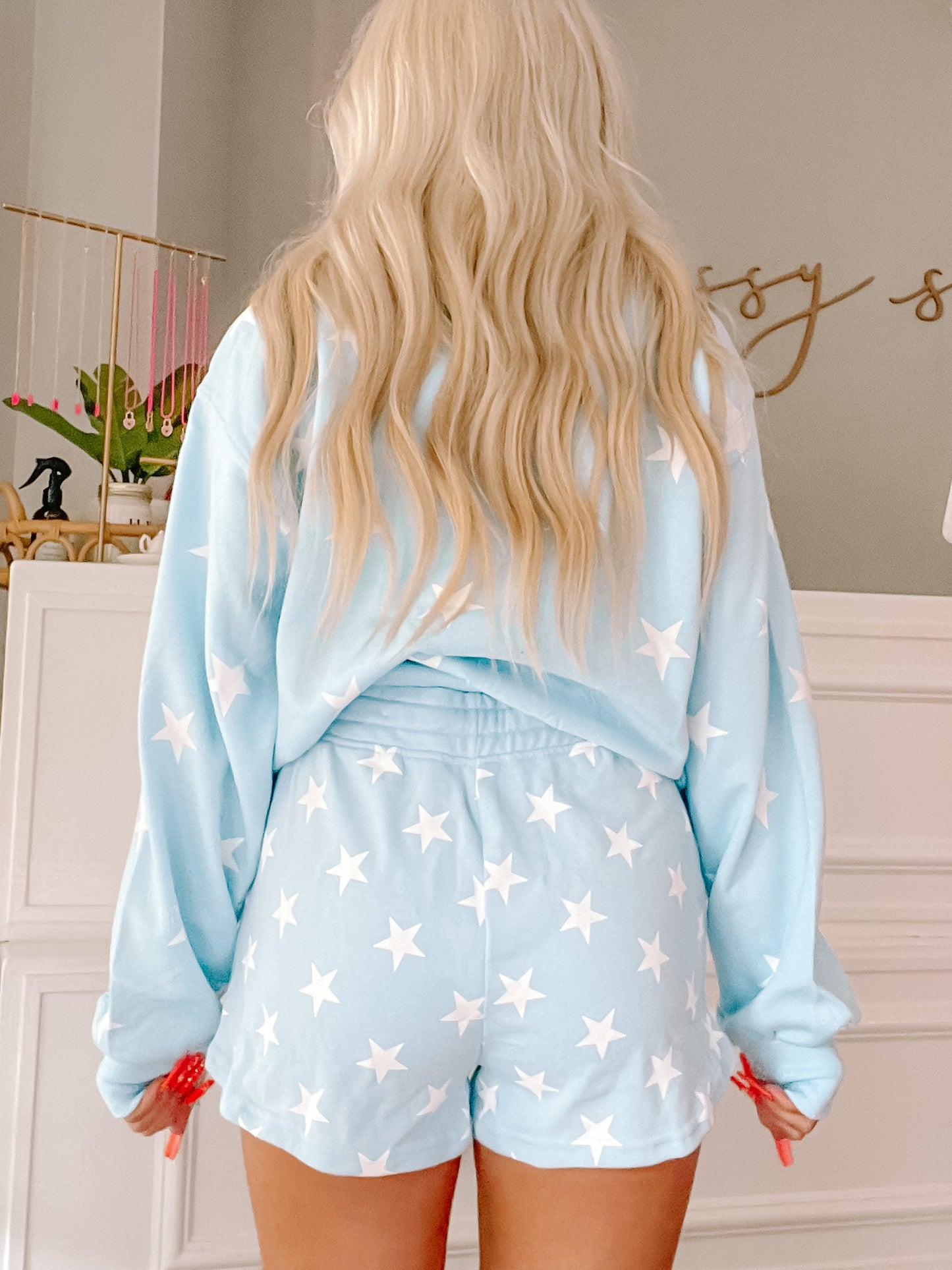 Light blue shorts with white stars, worn with a matching sweatshirt.