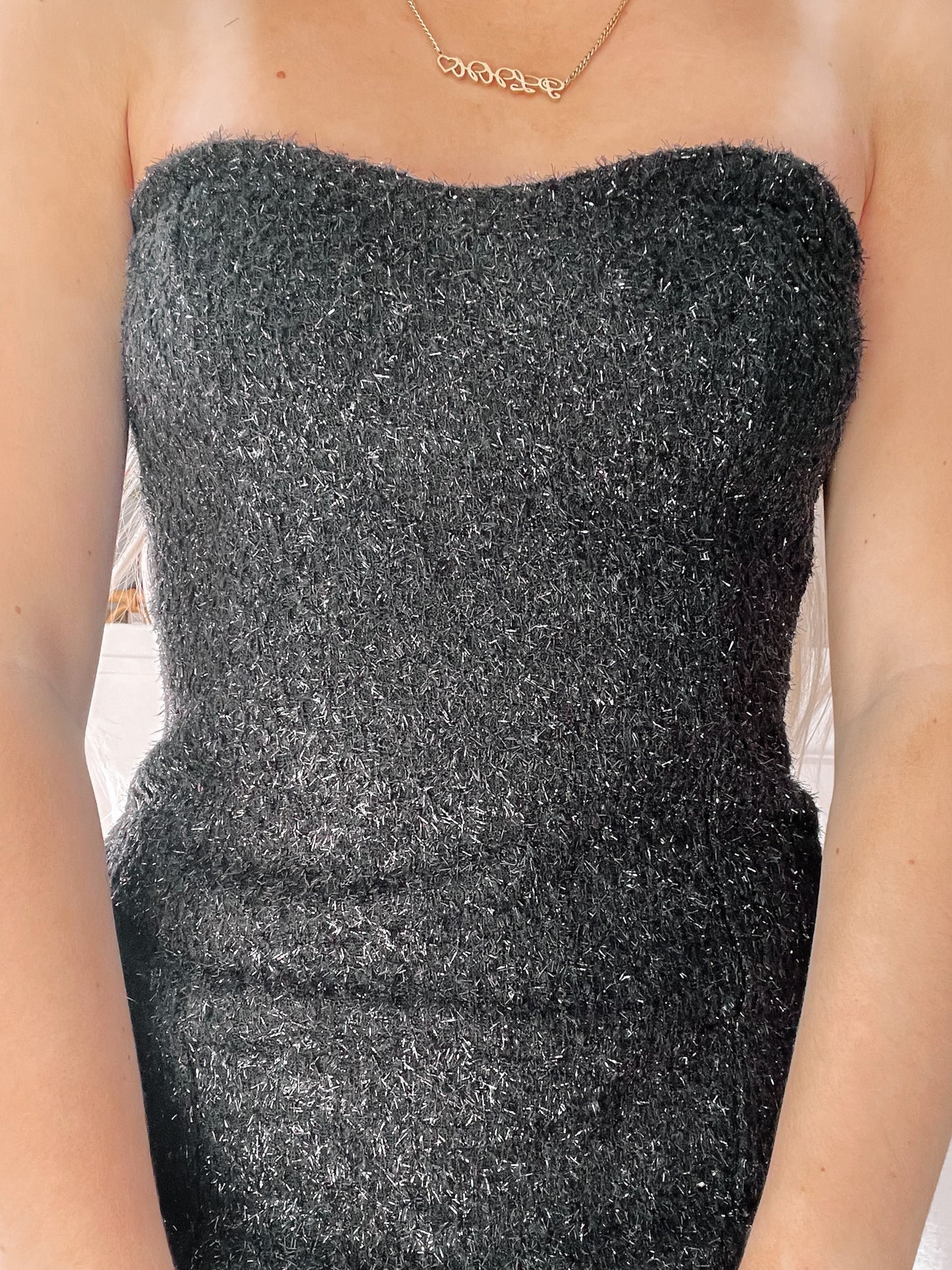 Sparkly black strapless mini dress, detailed close-up.