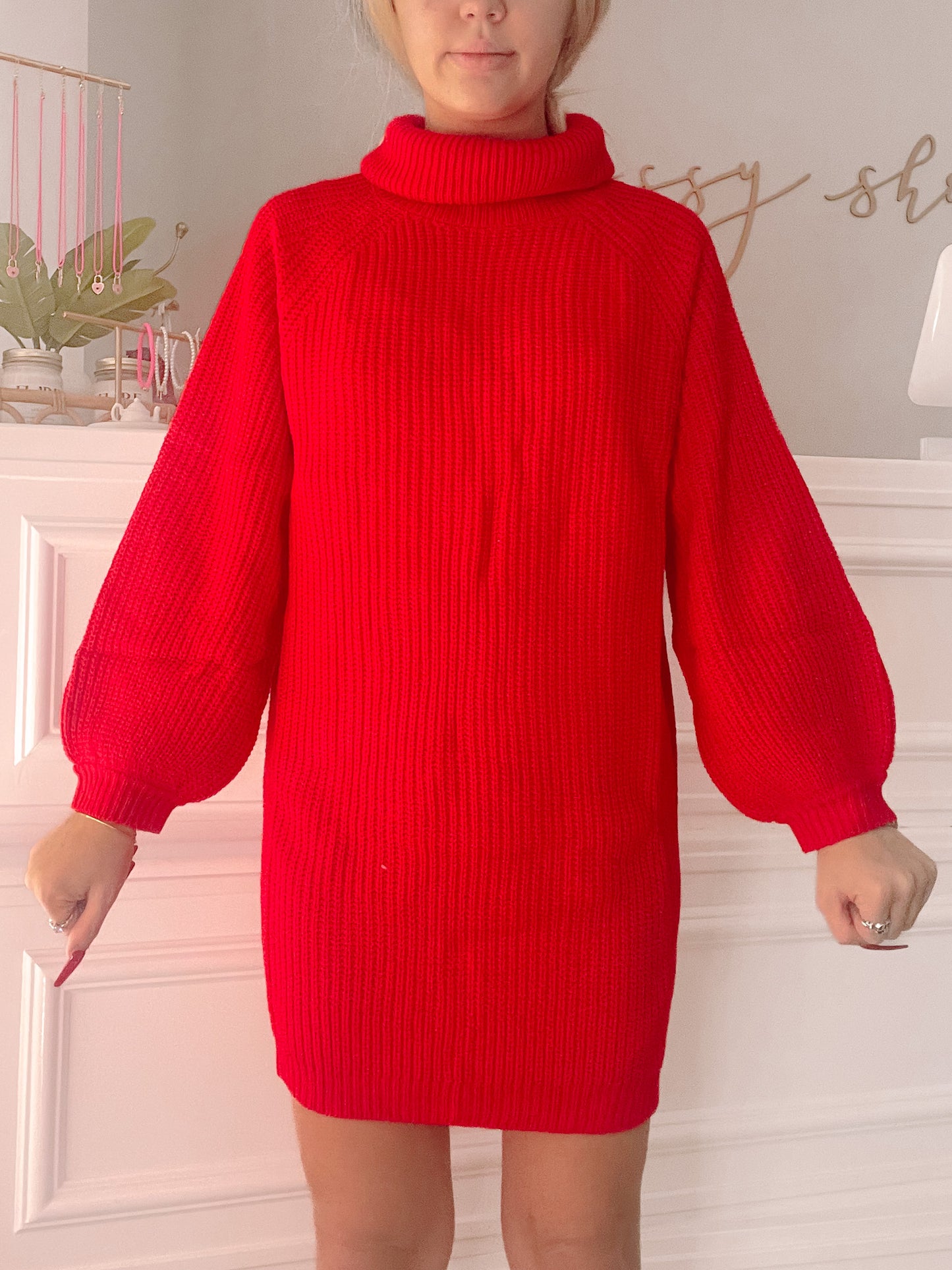 Red ribbed knit turtleneck sweater dress with balloon sleeves, shown on a model.