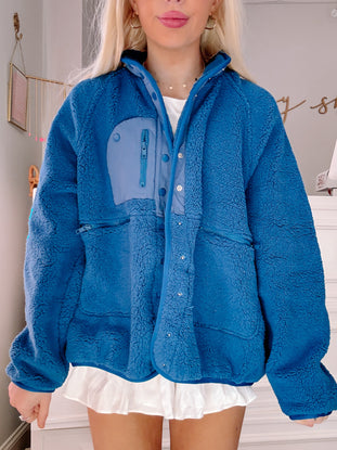 Blue sherpa jacket with contrasting pocket detail, shown on a model.