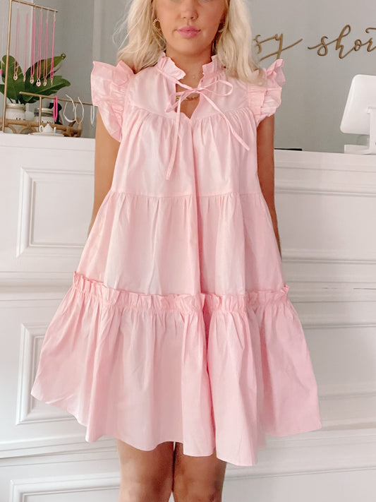 Pink tiered mini dress with ruffle sleeves and a keyhole neckline, shown on a model.