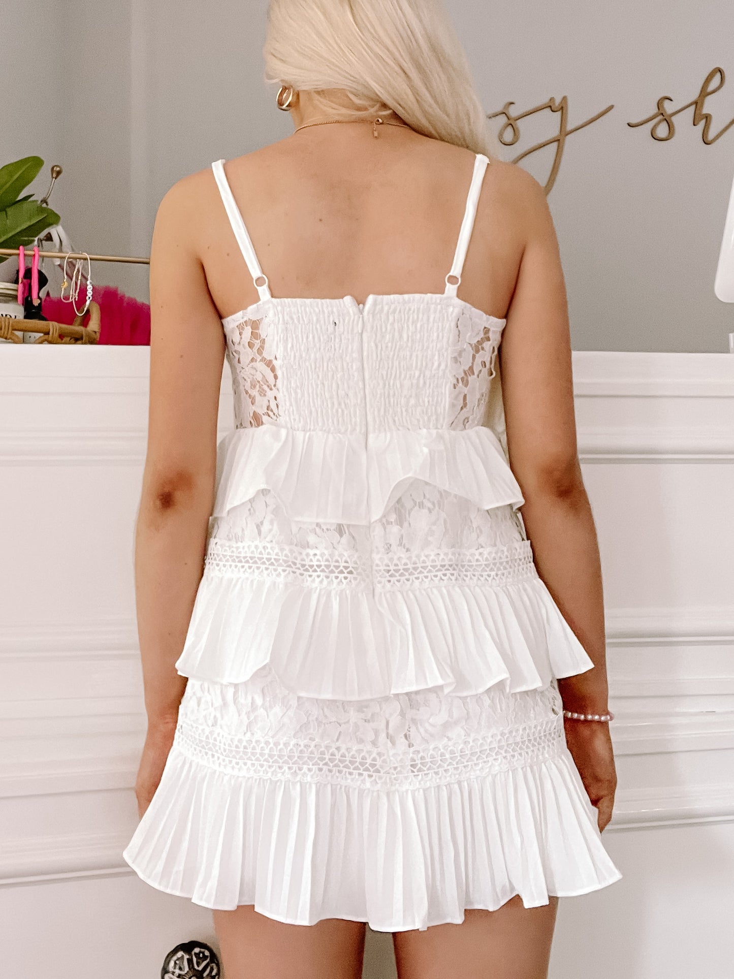 White eyelet and pleated mini dress; back view.