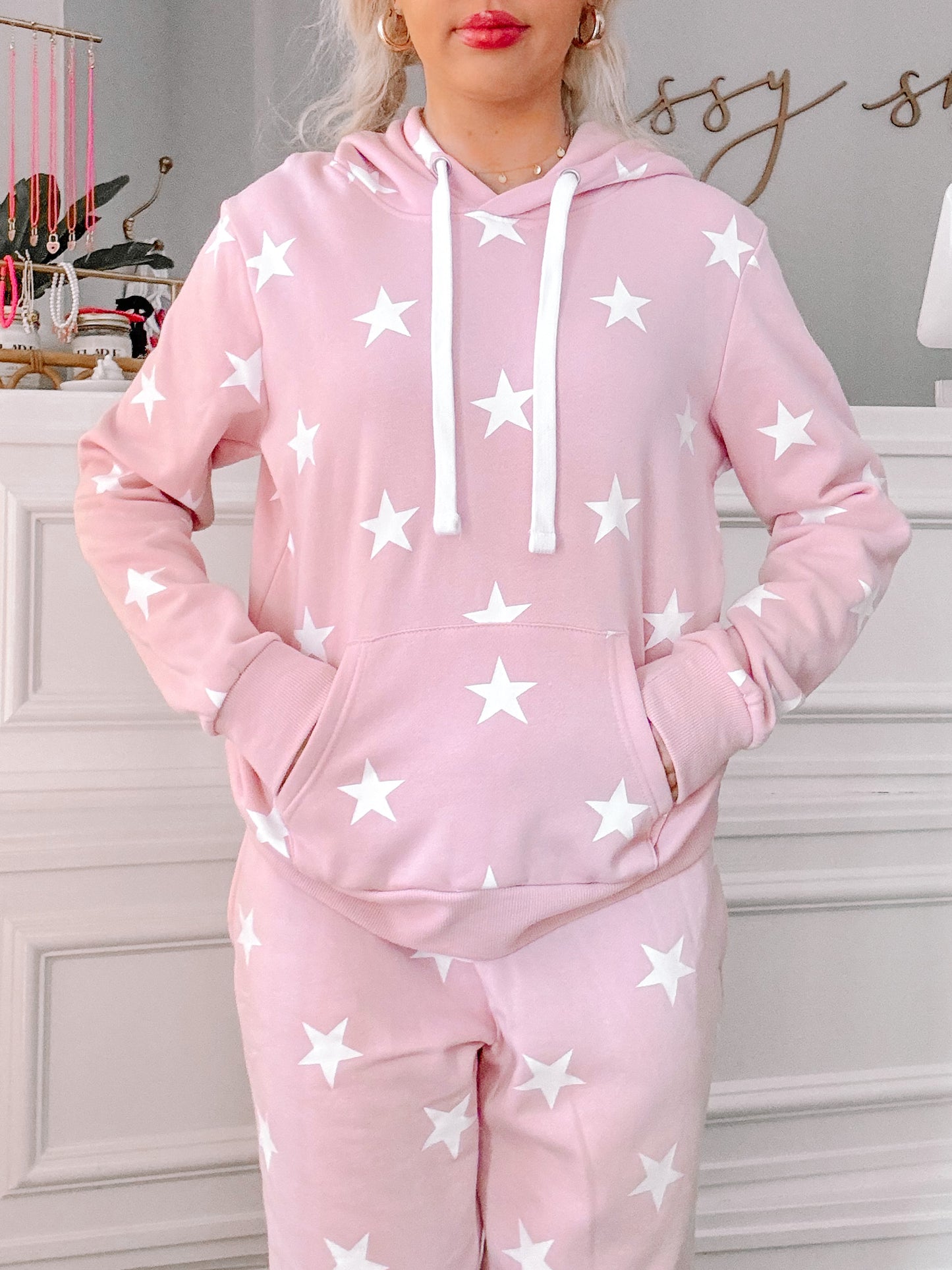 Pink hoodie and sweatpants set, featuring a white star pattern.