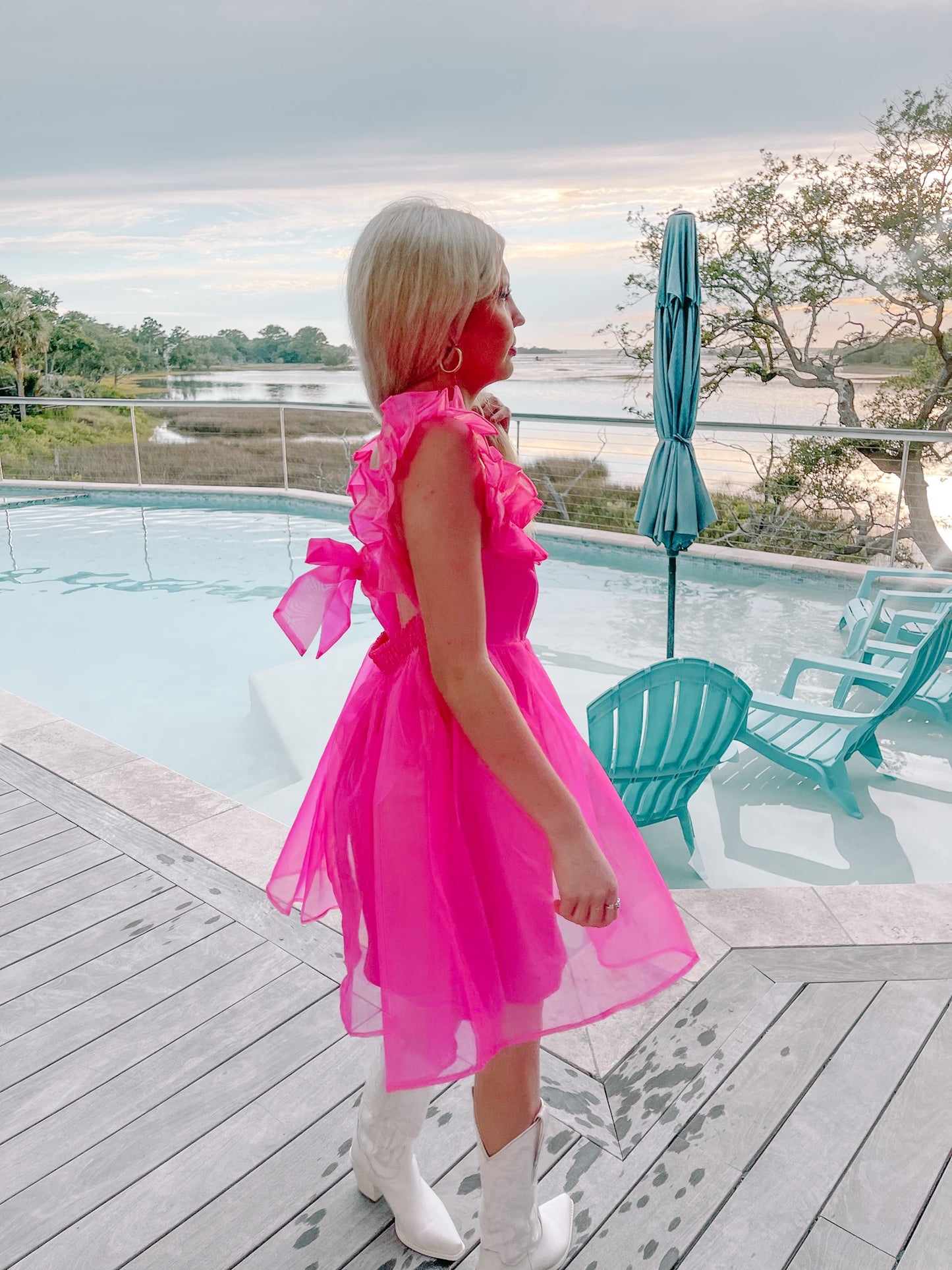 Hot pink mini dress with ruffle sleeves, worn poolside.