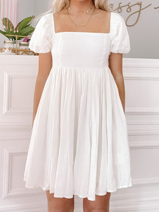 Ivory mini dress with puff sleeves and a square neckline, shown on a model.