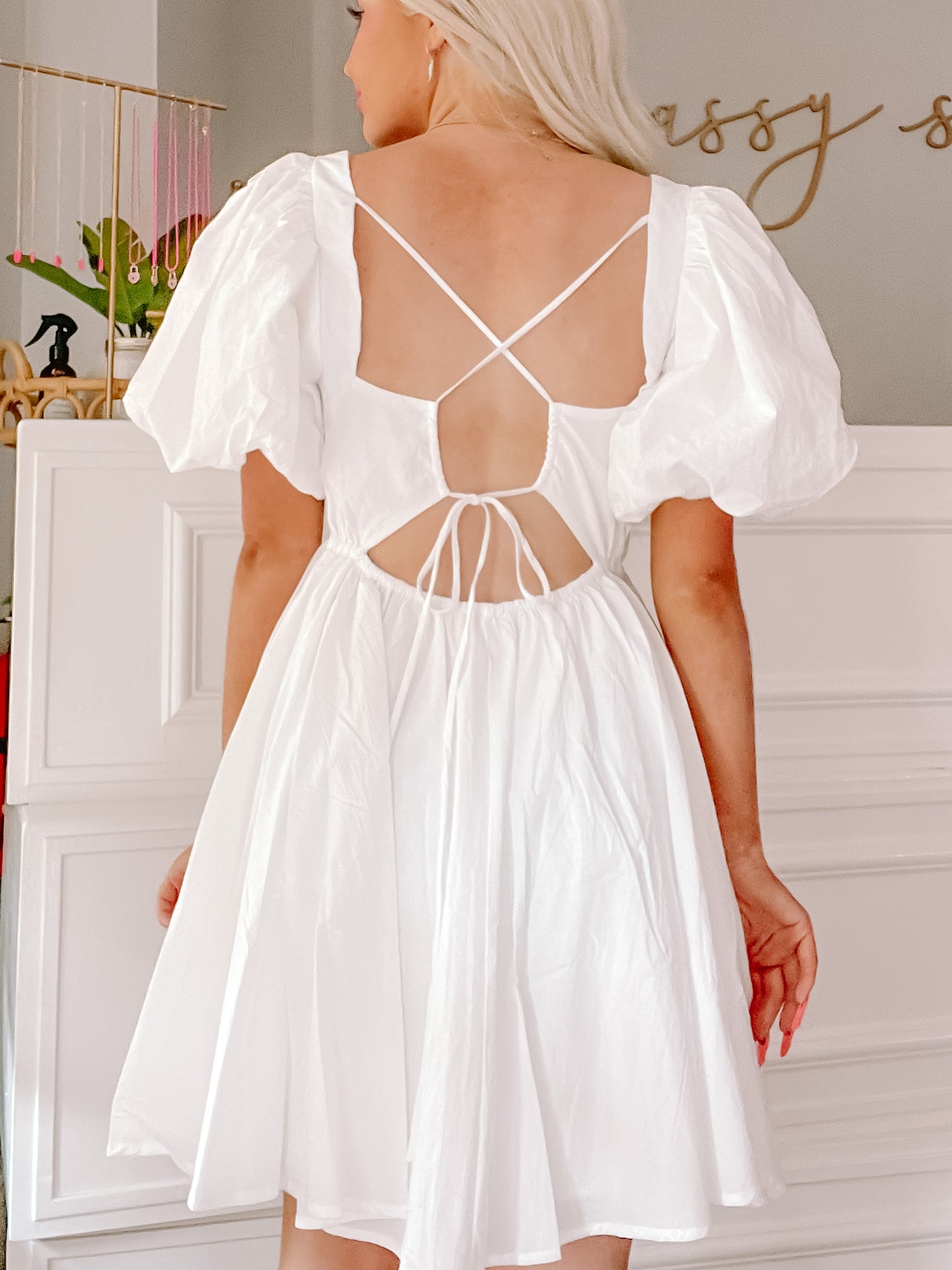 White puff-sleeve mini dress with criss-cross back detail.