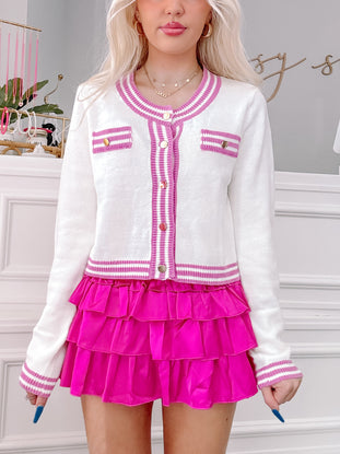 Coco Cozy Sweater: Cream knit cardigan with pink trim, gold buttons, and patch pockets.