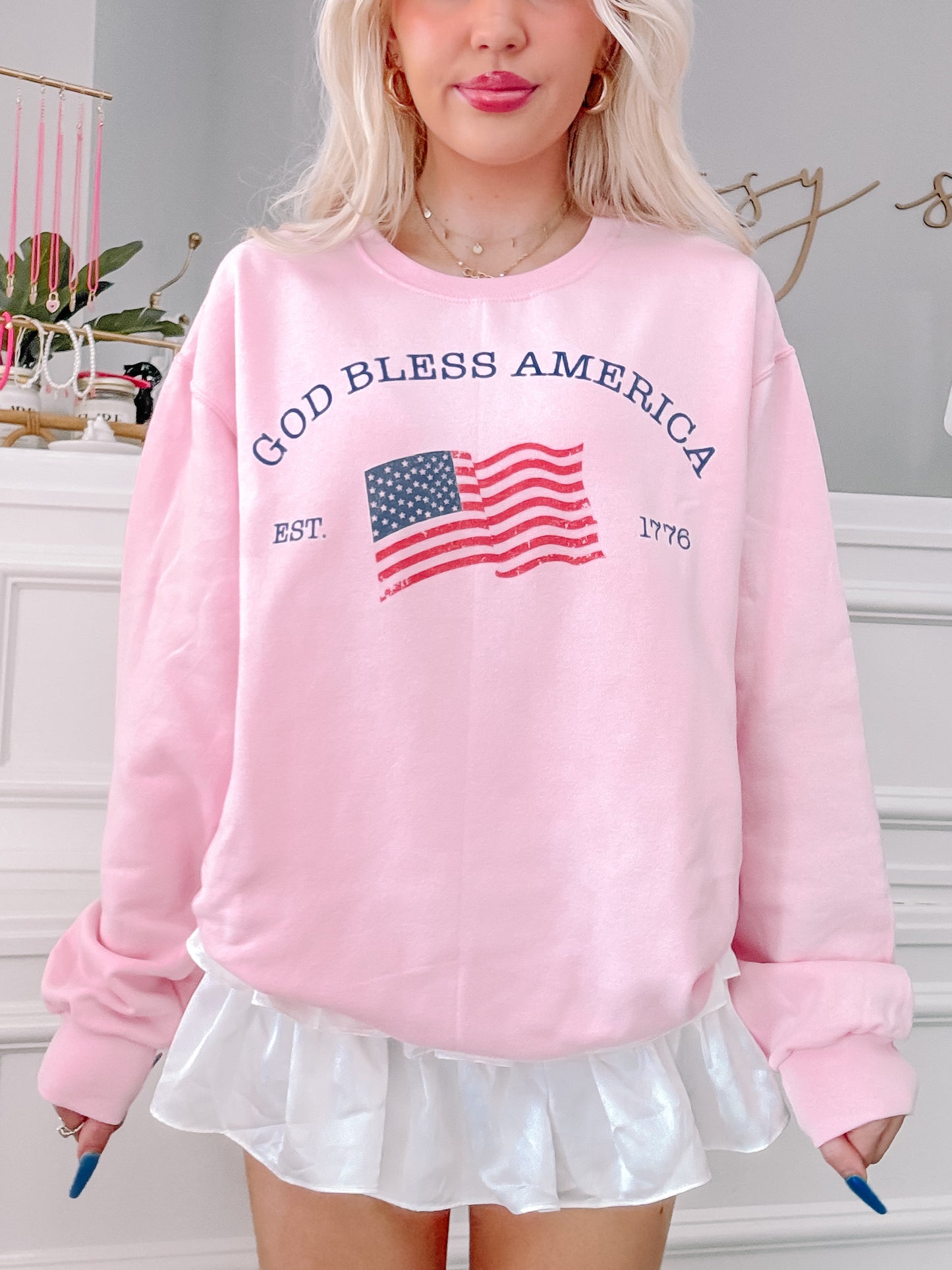 Pink "God Bless America" crewneck sweatshirt with distressed American flag graphic
