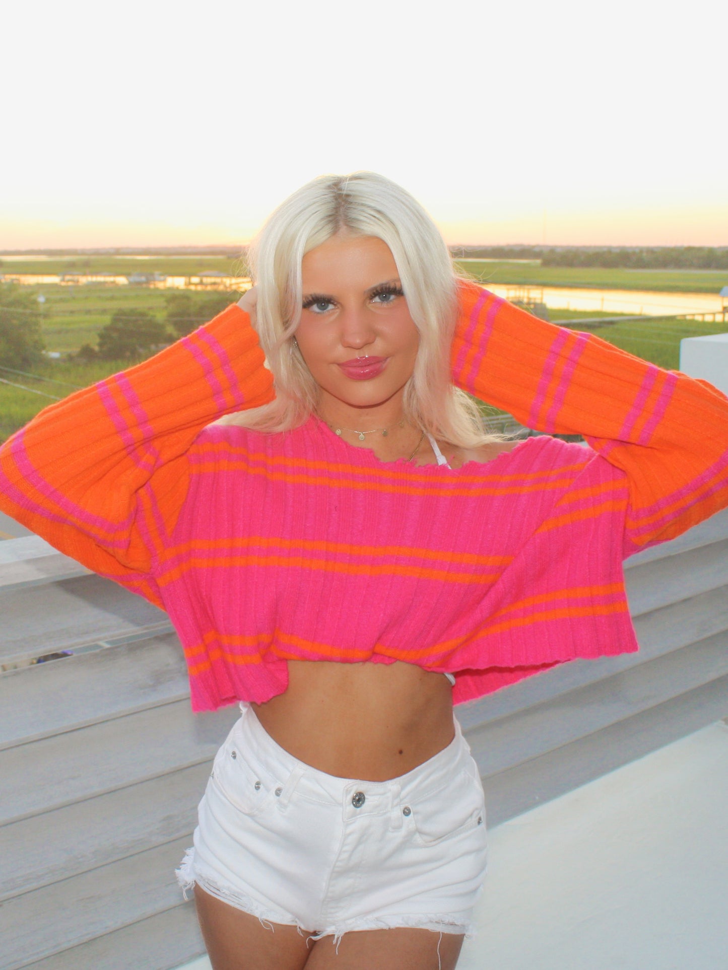 Pink and orange striped cropped sweater, worn outdoors at sunset.