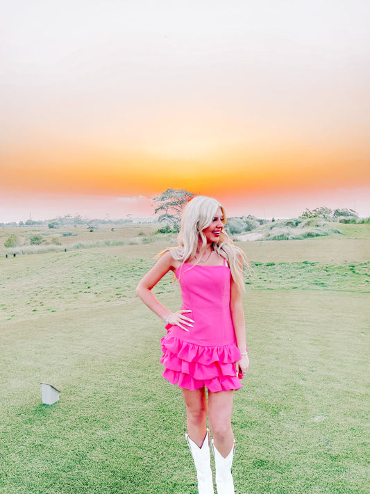 Pink dress with tiered ruffles, worn outdoors at sunset.