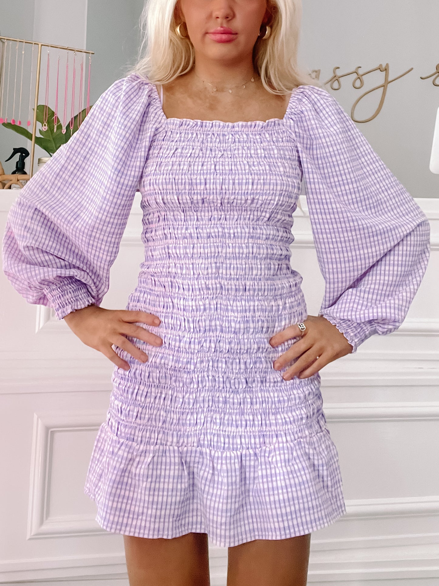 Lavender gingham smock dress with puffed sleeves and a fitted waist.