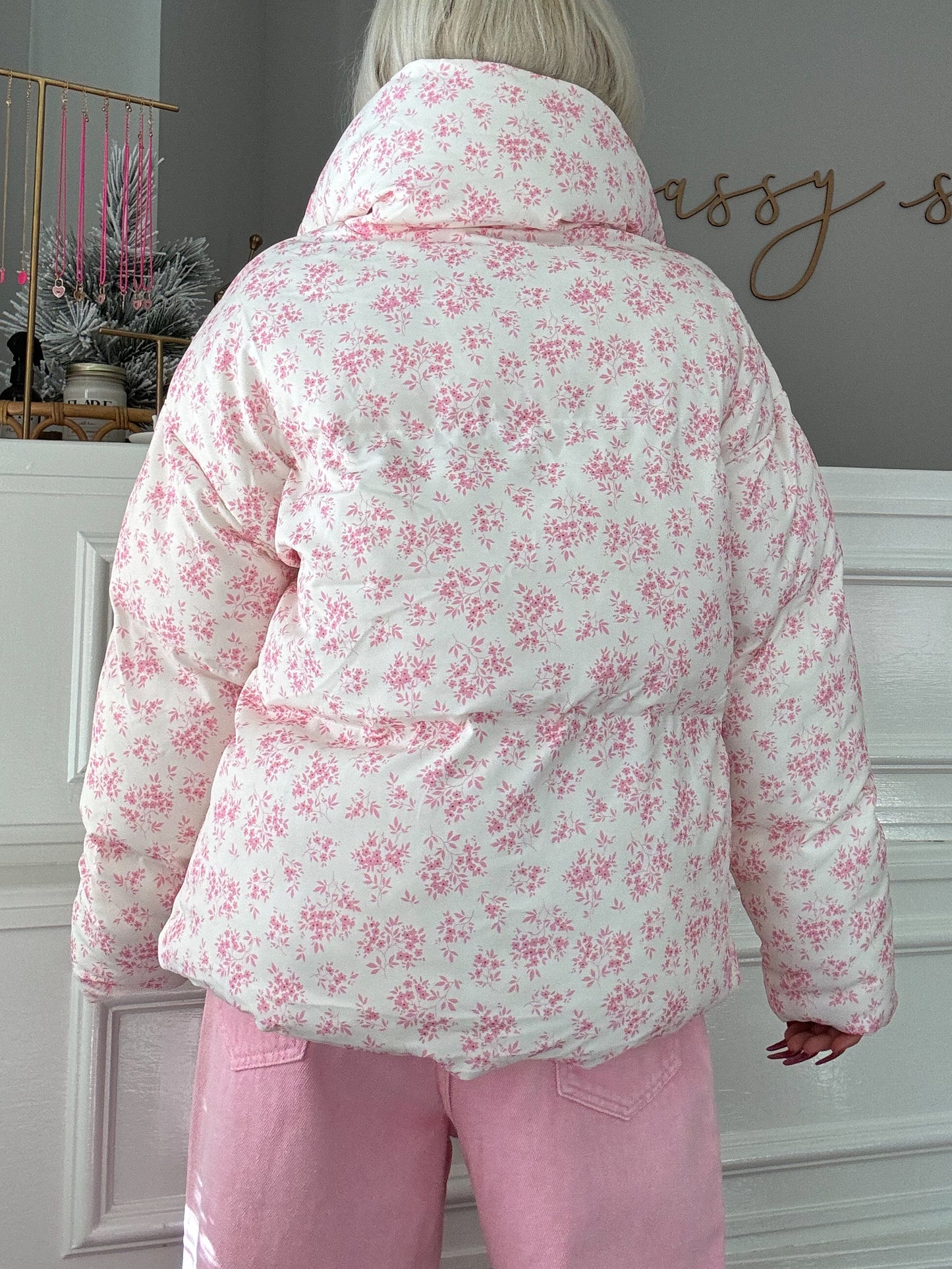 White puffer jacket with pink floral print, shown from the back.