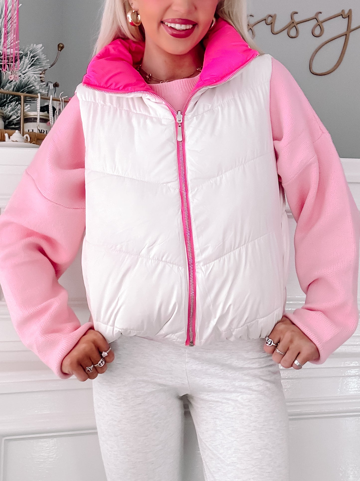 White and pink puffer vest with a zipper, styled with a pink sweater.