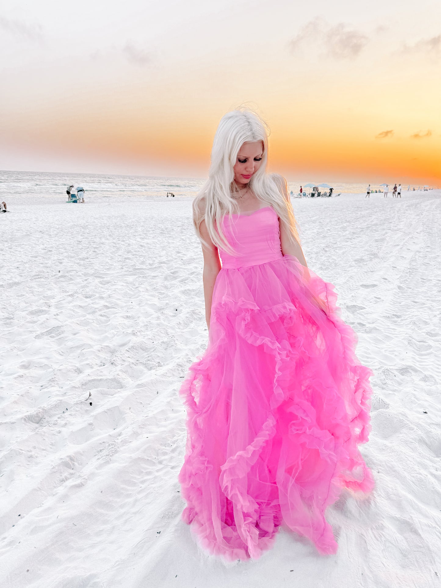 Hot pink tulle dress on a beach at sunset.