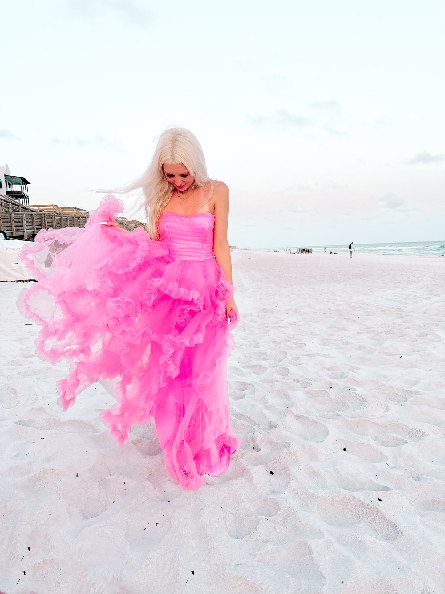 Blushing pink tulle dress on a sandy beach at sunset.