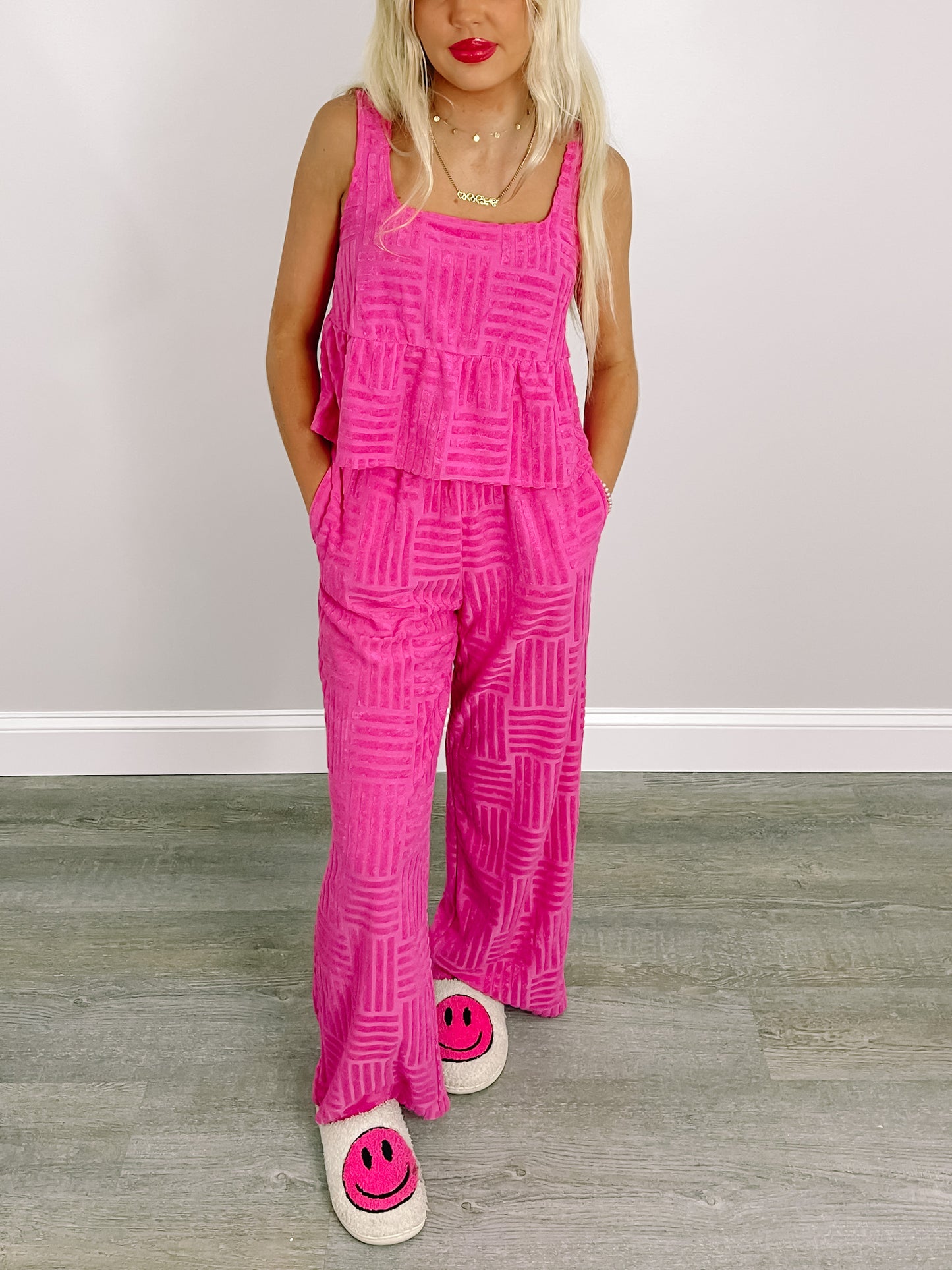Hot pink lounge set with textured pattern, modeled against a neutral backdrop.