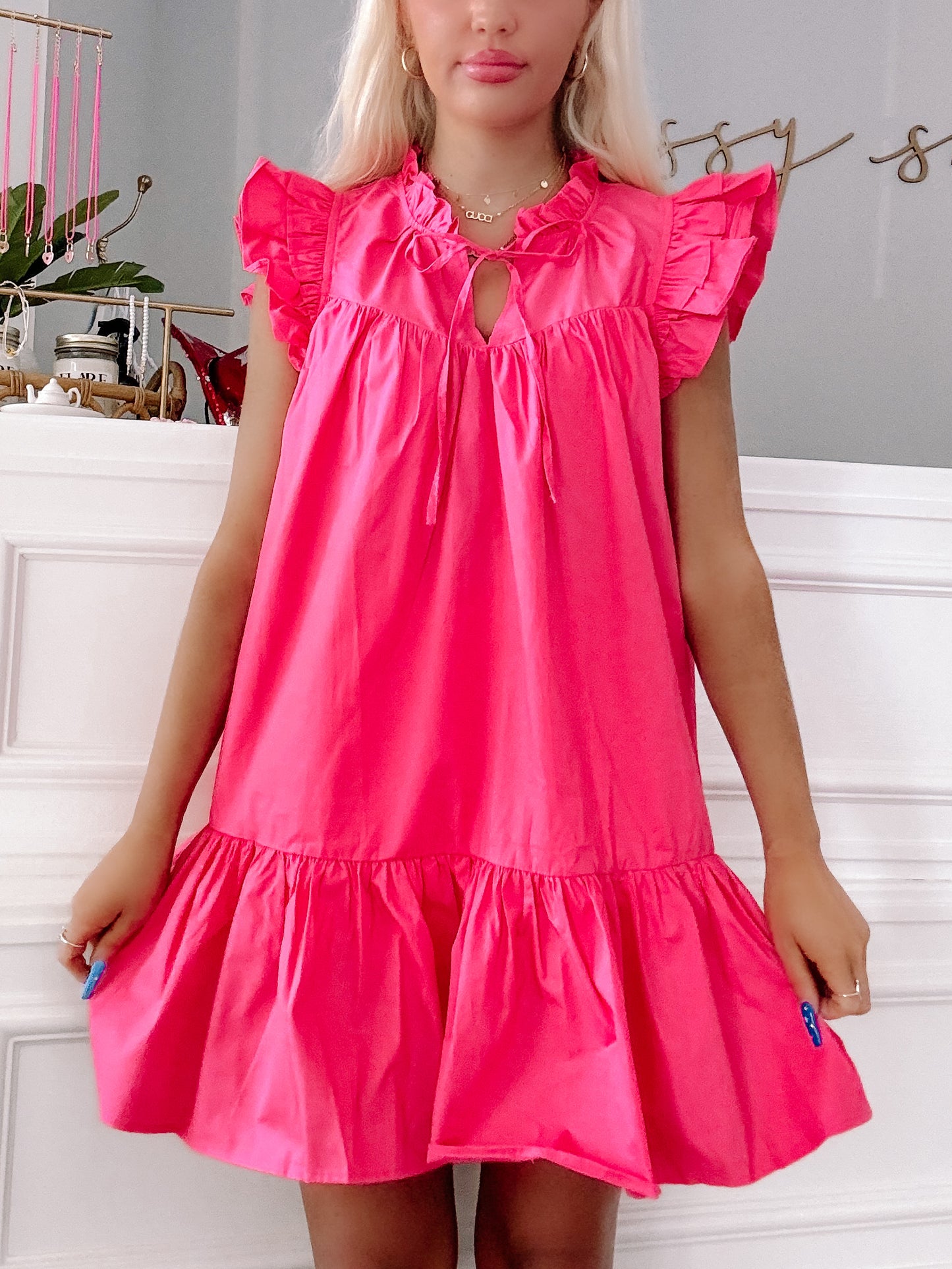Rose pink "Dressed to Impress" mini dress with ruffle sleeves and tiered skirt.
