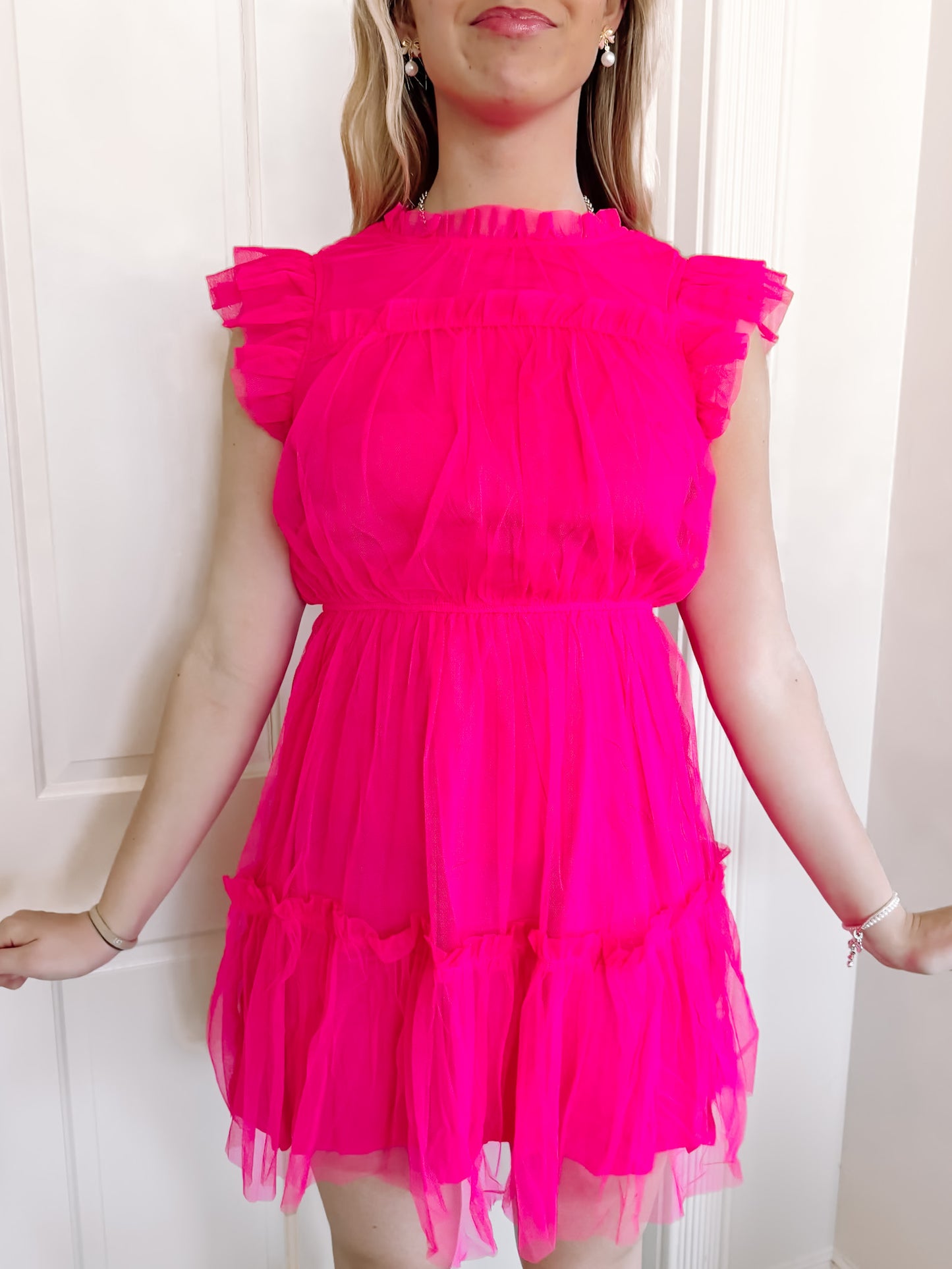Hot pink tulle mini dress with ruffle details.