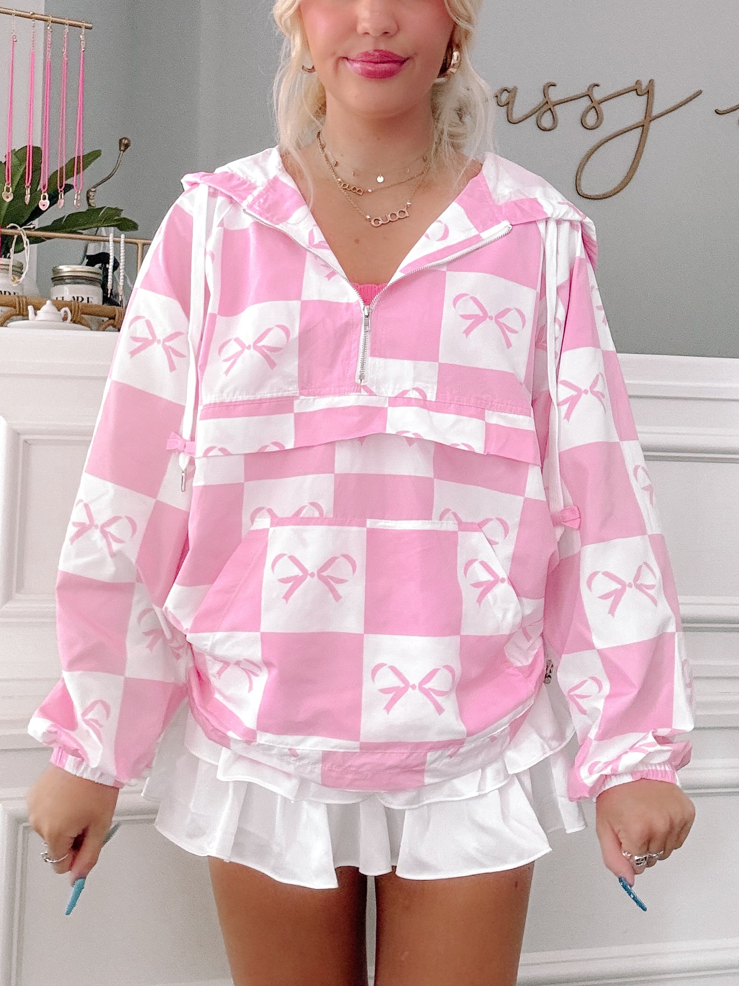 Pink checkered windbreaker with bow print, shown on model.