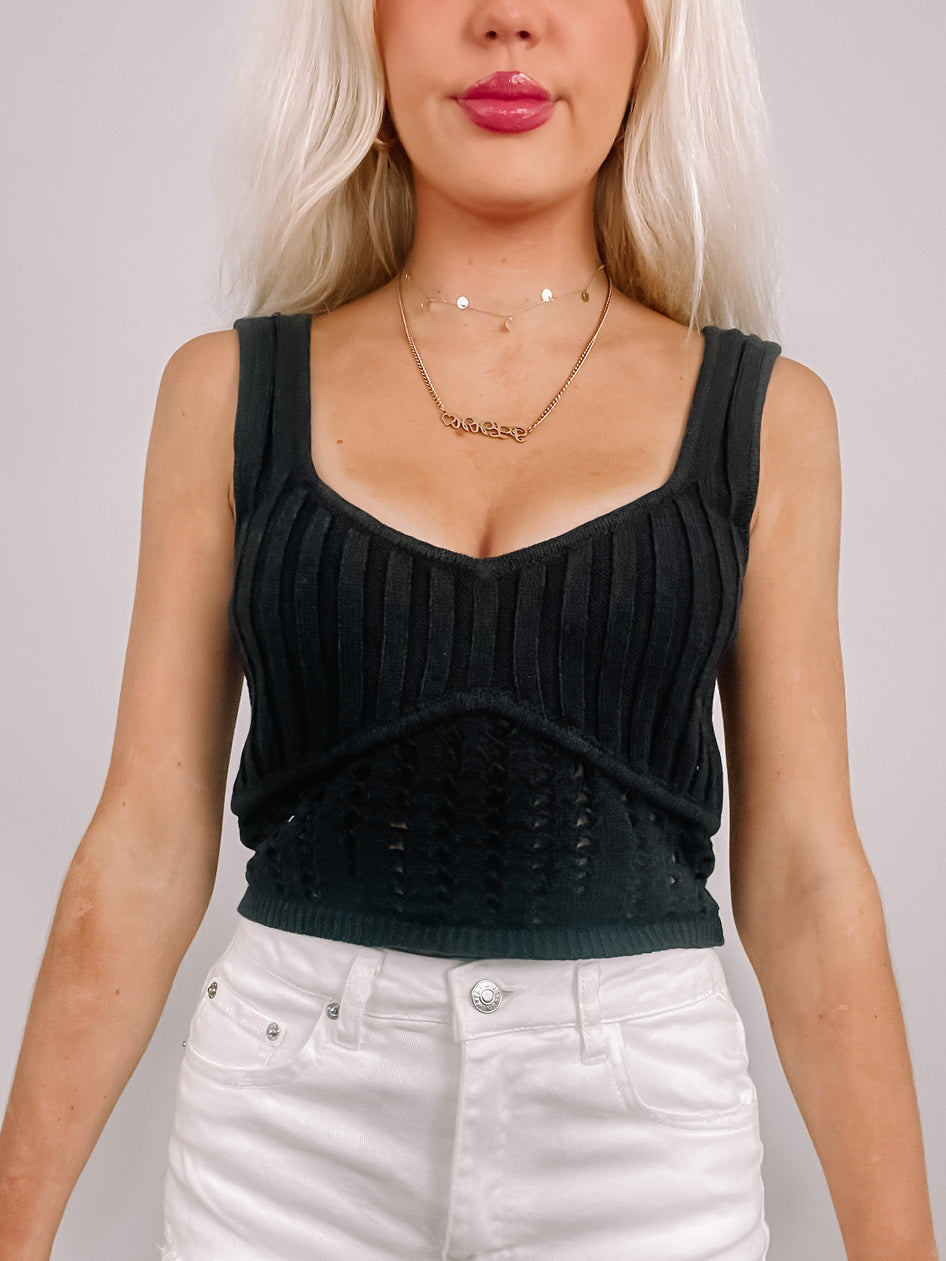 Black ribbed knit tank top with crochet detailing, styled with white jeans.
