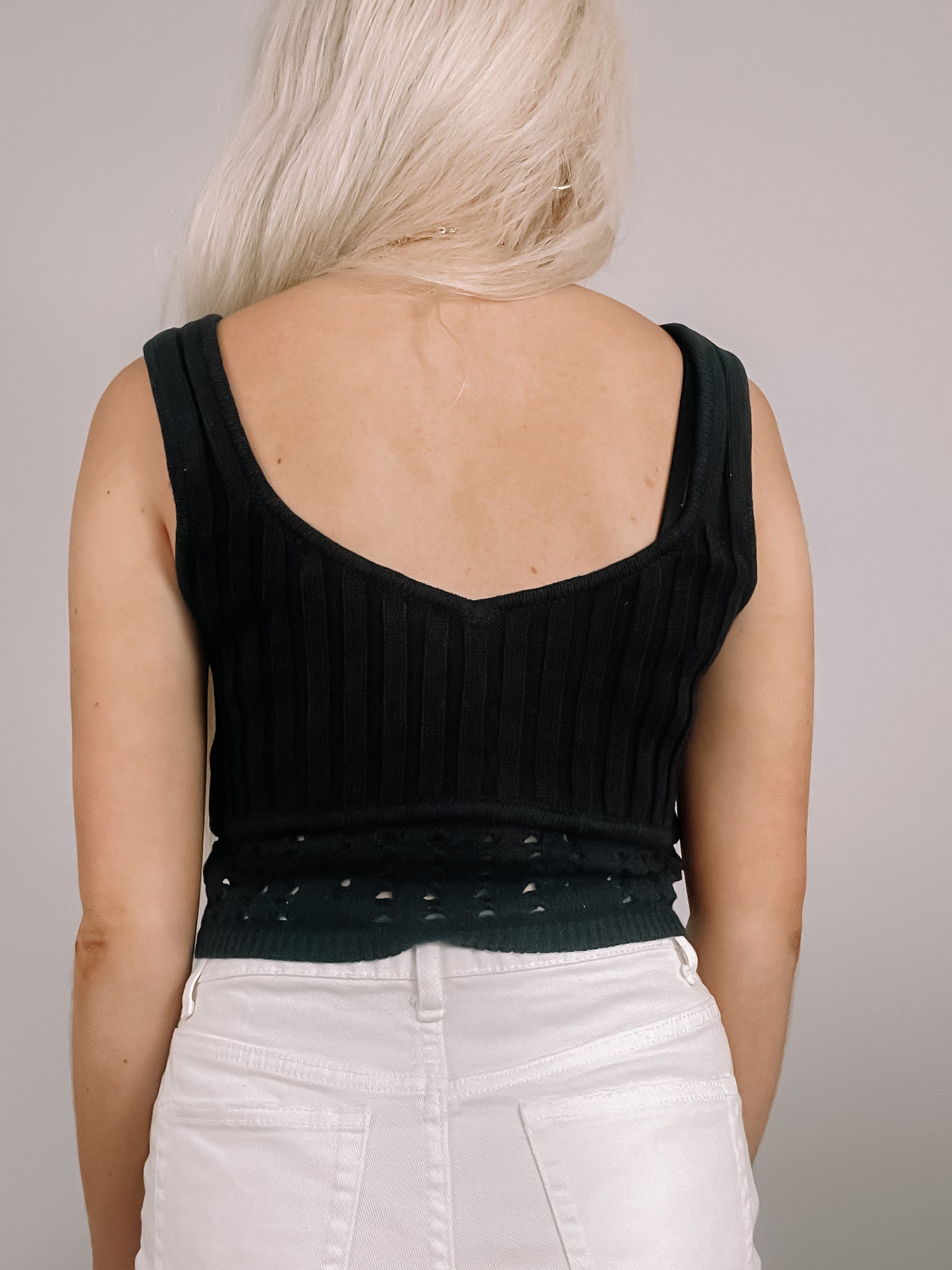 Black ribbed knit tank top with eyelet detailing, shown from the back.