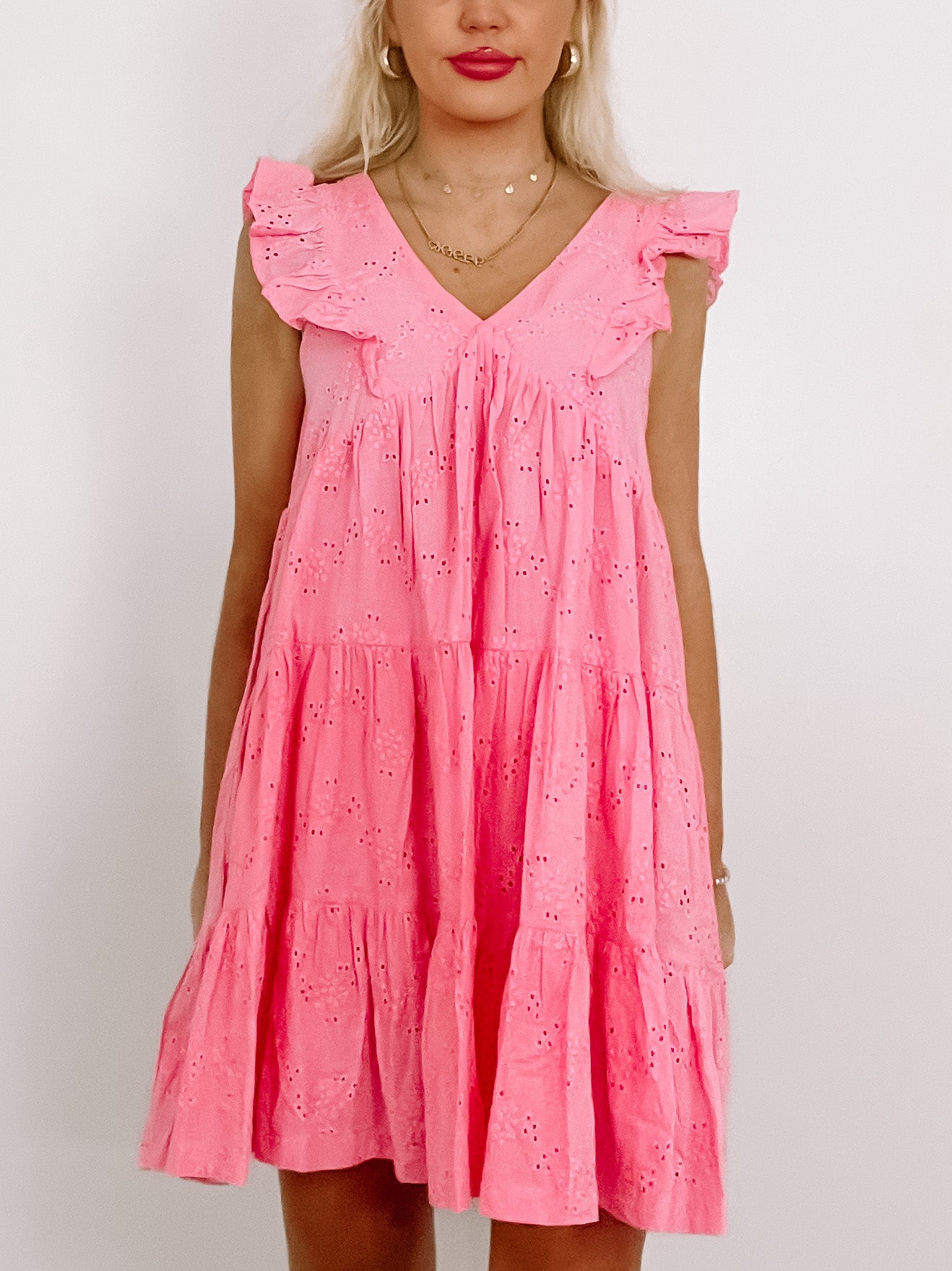 Pink Eyelet Island Dress: tiered, sleeveless mini dress with ruffle details.