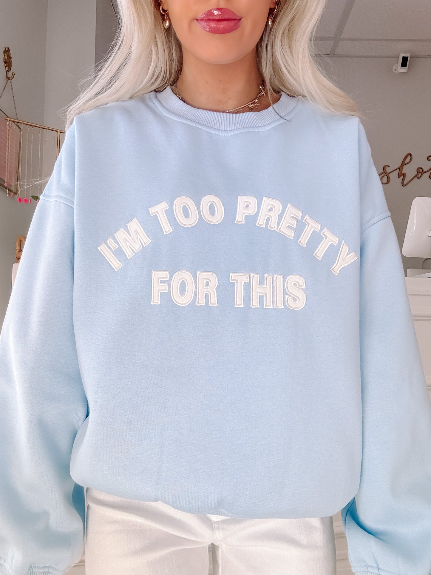 Light blue crewneck sweatshirt with "I'm too pretty for this" in white lettering.