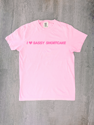 Pastel pink bow tee laid flat, red heart and Sassy Shortcake - I heart sassy shortcake merch tee