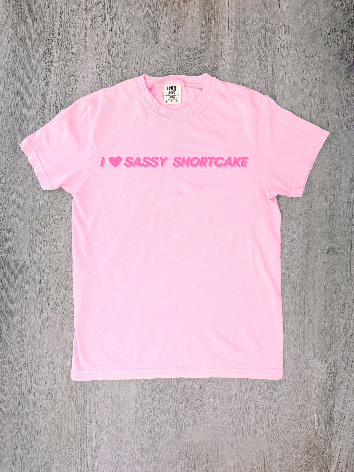 Pastel pink bow tee laid flat, red heart and Sassy Shortcake text clearly visible.
