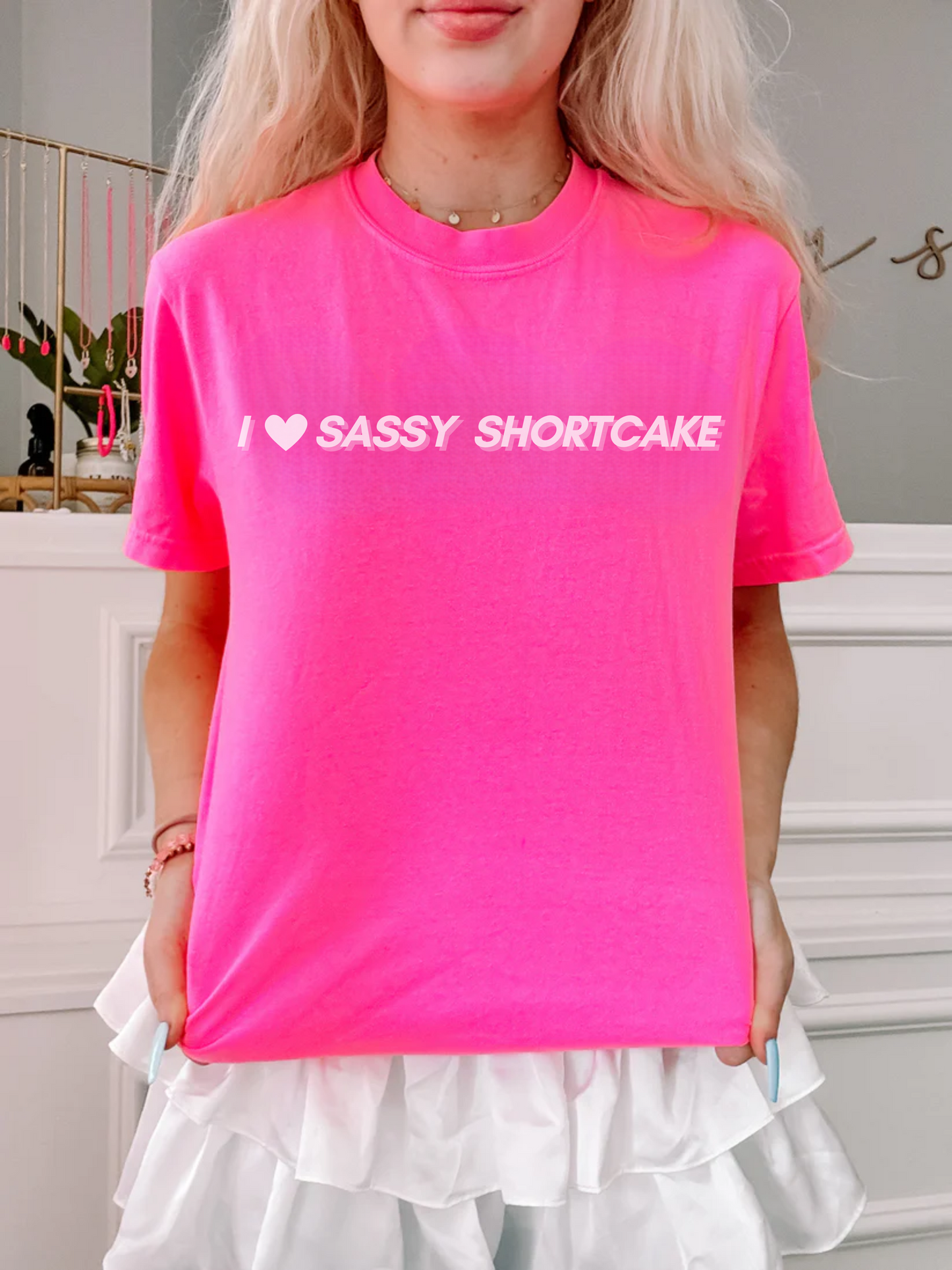 Model poses in hot pink tee with playful Sassy Shortcake slogan, clean studio lighting.