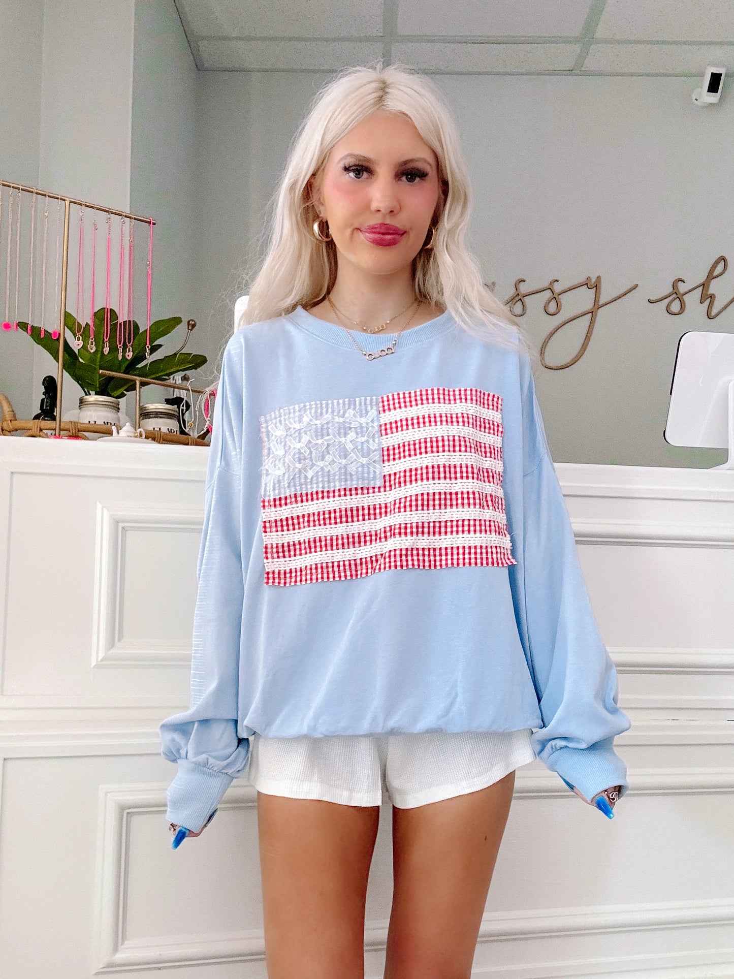 Front view of Sassy Shortcake’s Stars & Stitches Crewneck styled with white shorts.