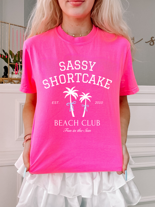 Pink Sassy Shortcake Beach Club Tee, "Fun in the Sun," palm tree graphic.