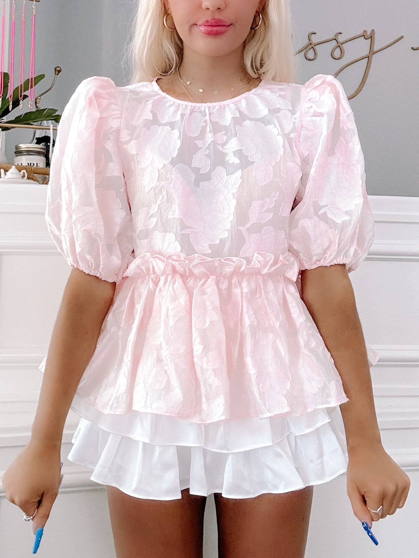 Pink floral puff-sleeve top with ruffled hem and layered white skirt.