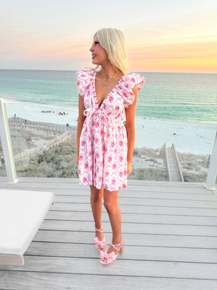 Floral print mini dress, worn on a deck overlooking the ocean at sunset.