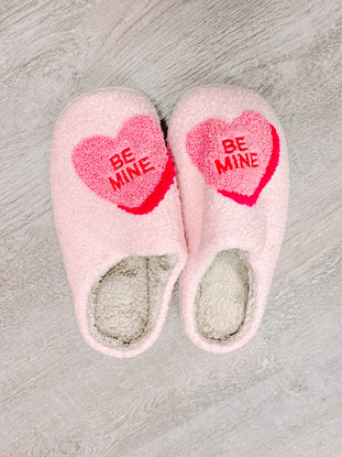 Pink "Be Mine" heart slippers, cozy and perfect for Valentine's Day.