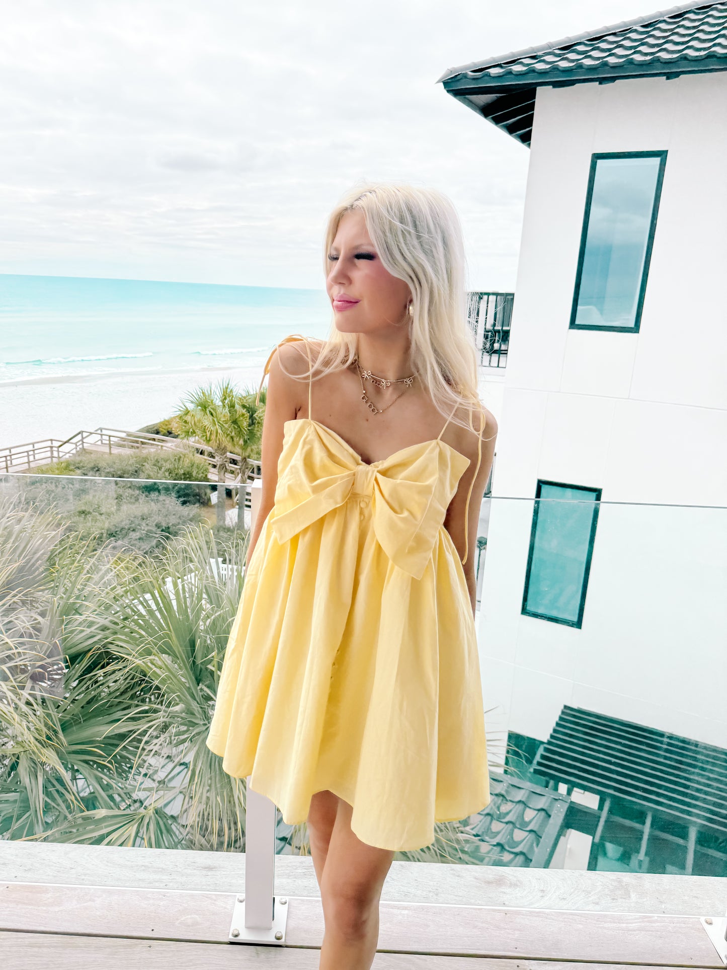 Yellow Bowshine babydoll mini dress styled on model, feminine spring outfit inspiration