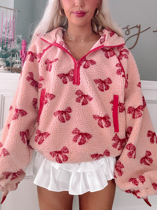 Pink Bundled in Bows pullover, cozy sherpa fleece with red bow print.