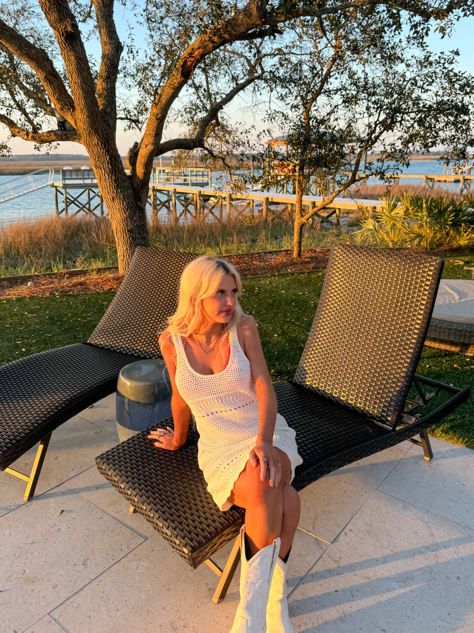 Side view of ivory sleeveless mini dress showing texture and length.