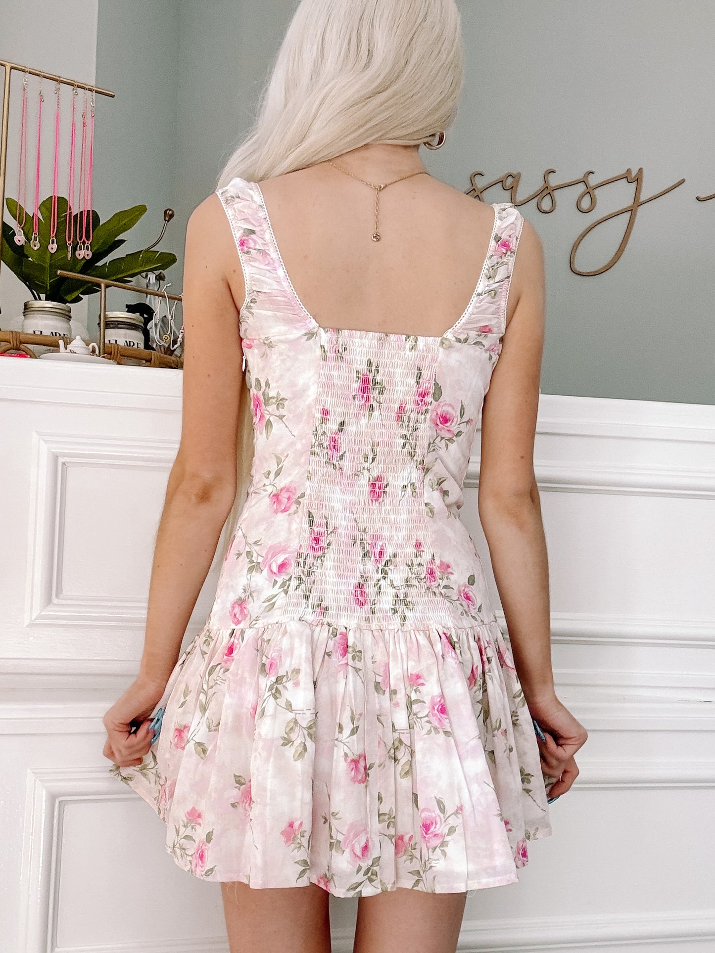 Pink floral dress, rear view, showcasing a smocked bodice and tiered skirt.