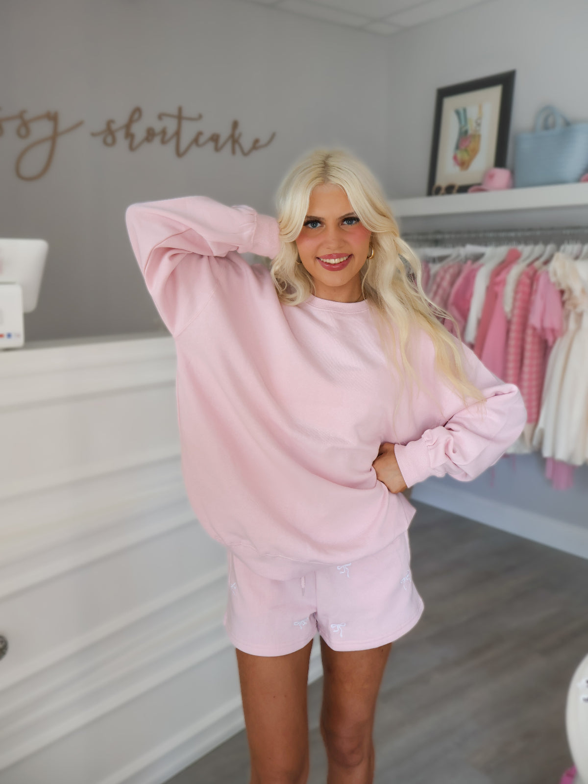 Model wearing embroidered pink bow shorts from Sassy Shortcake in boutique setting