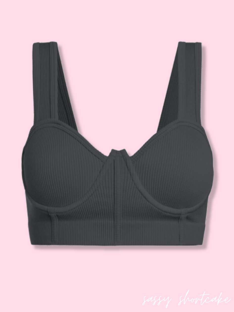 Charcoal ribbed bra top against a pink background.